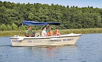 Eine Familie fährt in einem Motorsportboot über einen hübschen See.