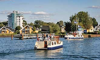 Ein Hausboot fährt in Richtung Hafendorf Müritz.