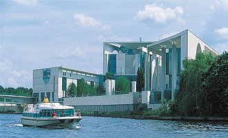 Ein Hausboot fährt durch Berlin vorbei am Bundeskanzleramt.
