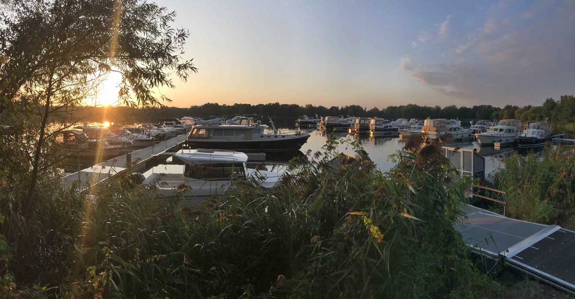 Viele angelegte Boote am Hafen bei Sonnenuntergang