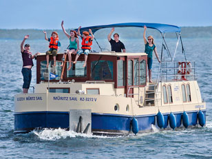 Das Hausboot Kormoran 1280 auf der Müritz unterwegs mit einer Gruppe an Bord